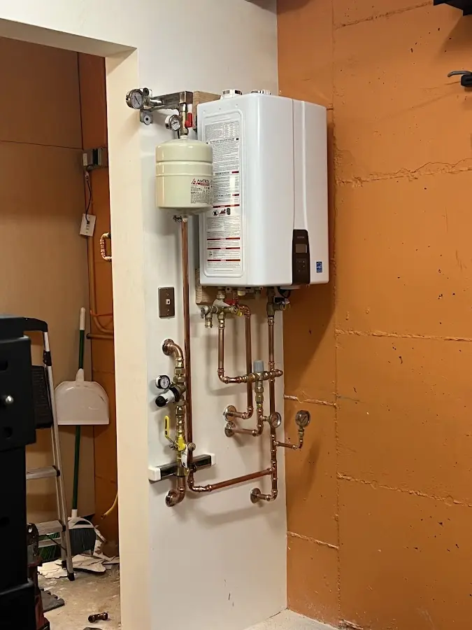 Plumbing technician inspecting water heater connections in West Chicago